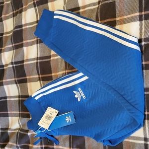 Blue adidas track pants.